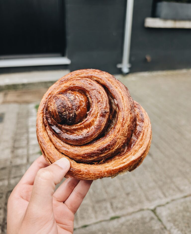 A picture of a pastry roll being held by a hand.