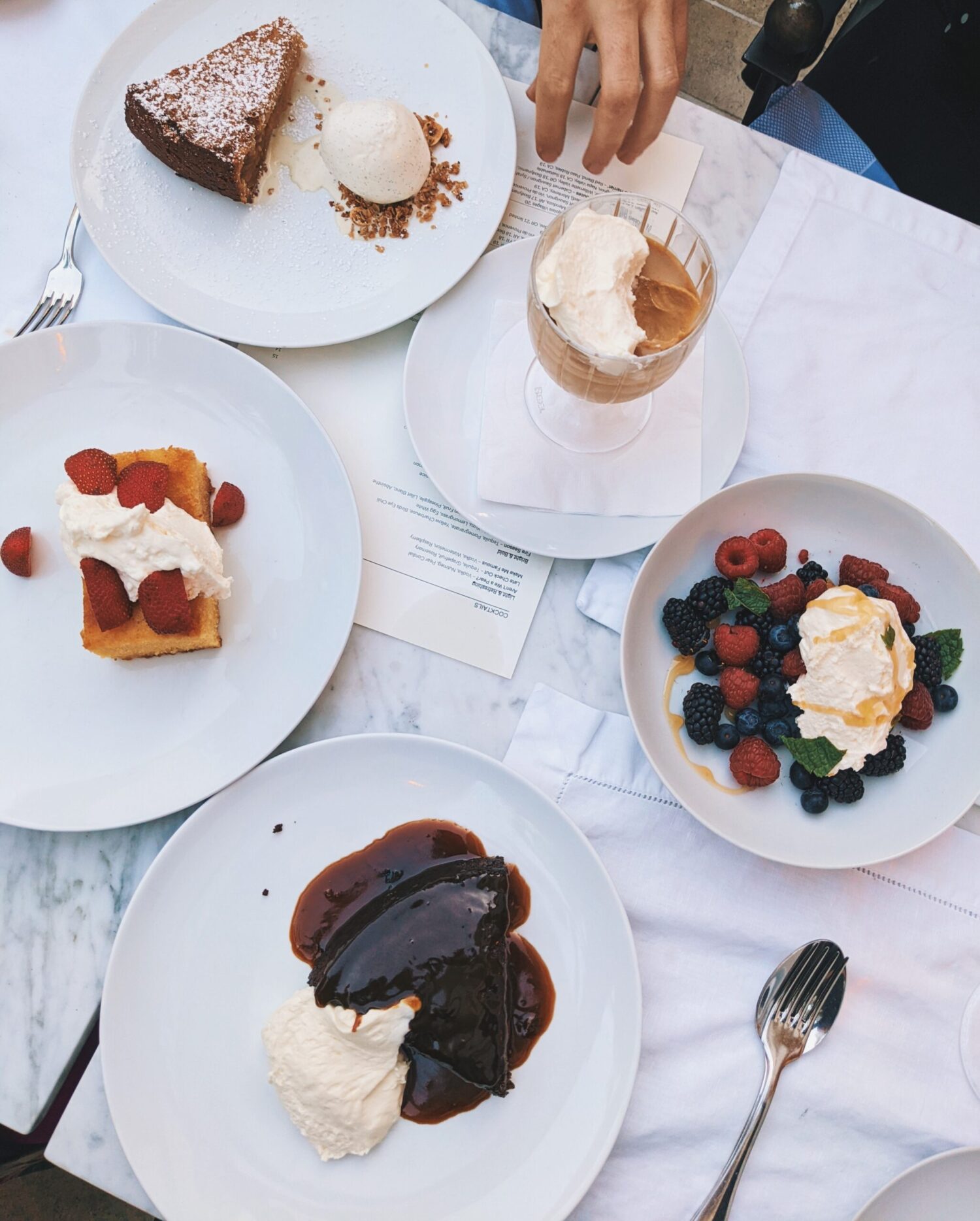 A picture of a table with various desserts on it.