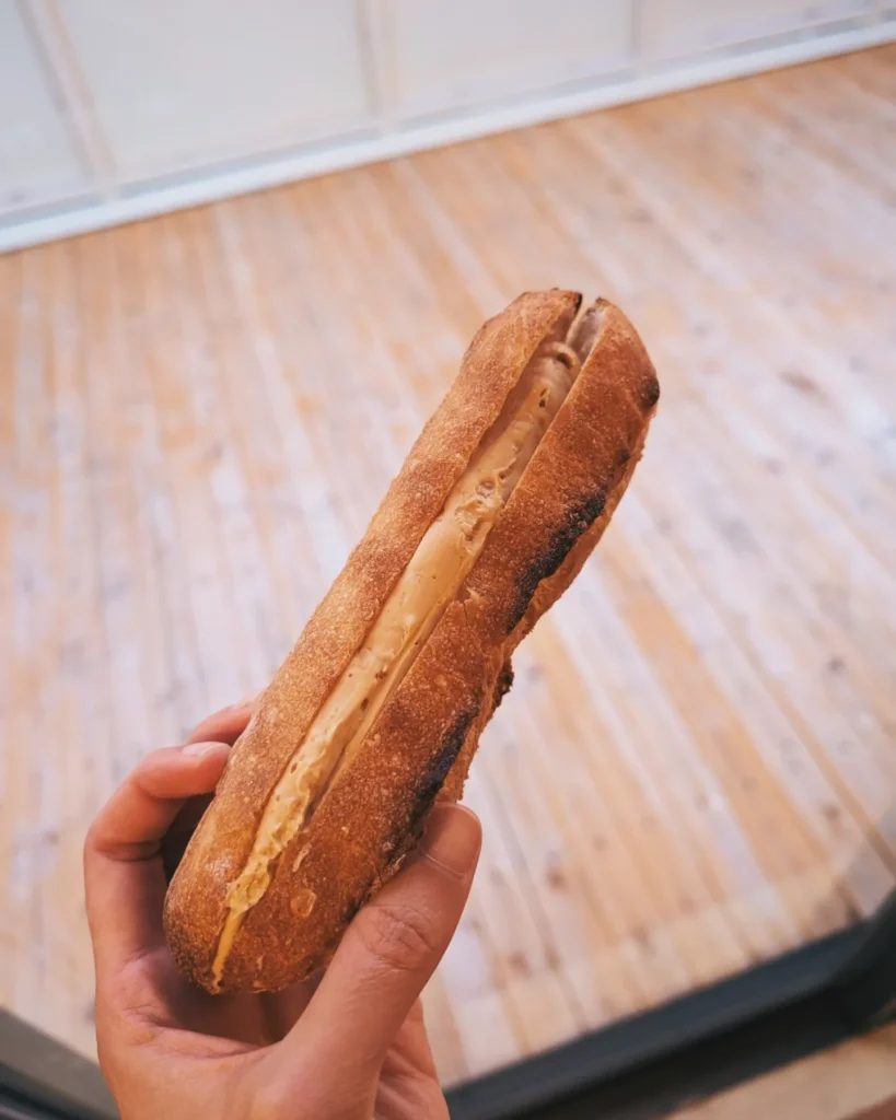 A picture of a piece of bread filled with peanut butter butter filling.